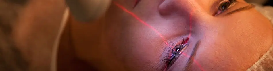 Augenlasern München MUNICH EYE Frau lässt sich die Augen Lasern - der Laser markiert das linke Auge mit einem Fadenkreuz.